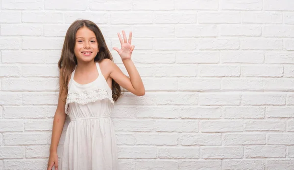 Junge Hispanische Kind Über Weiße Backsteinmauer Zeigt Und Zeigt Mit — Stockfoto