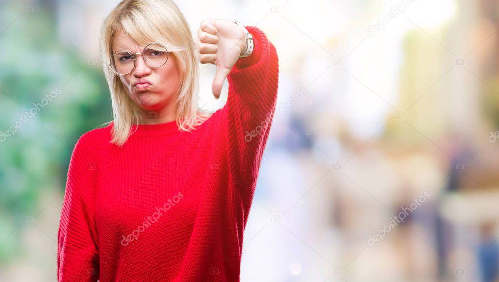 Young beautiful blonde woman wearing sweater and glasses over isolated background looking unhappy and angry showing rejection and negative with thumbs down gesture. Bad expression.