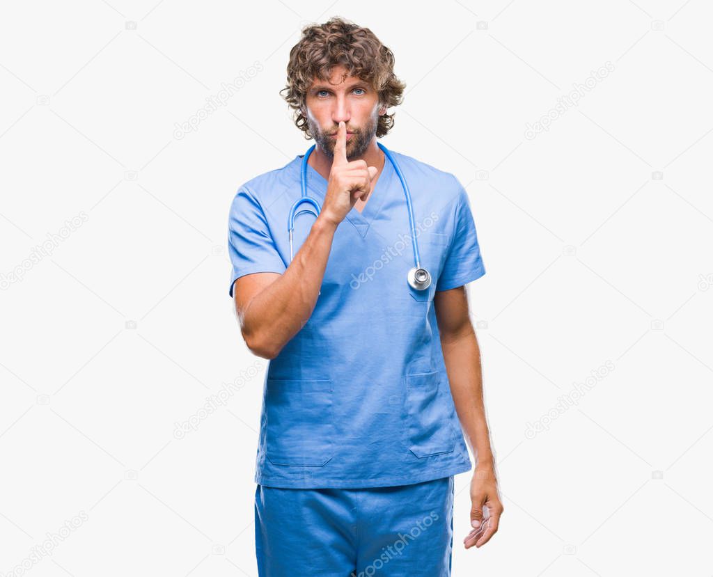 Handsome hispanic surgeon doctor man over isolated background asking to be quiet with finger on lips. Silence and secret concept.