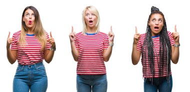 Kolaj giyen genç kadınların t-shirt hayrete ve yukarıya bakıyor ve parmakları ile işaret ve silah kaldırdı sürpriz izole arka plan üzerinde çizgili..