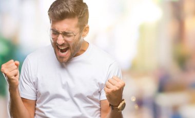 Gülümseyen ve başarı için çığlık izole arka plan çok mutlu ve heyecanlı kaldırdı, silah ile kazanan jest yapıyor üzerinde gözlük takan yakışıklı delikanlı. Kutlama kavramı.