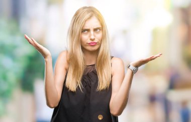 Genç güzel sarışın ve mavi gözlü kadın izole arka plan clueless ve şaşkın bir ifadeyle kollar ve eller kaldırdı. Şüphe kavramı.