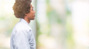 Afro Amerikalı adam giyen karate kimono izole arka tarafına, seyir üzerinde dinlenmek doğal yüz emin gülümseme ile pozuyla profili.