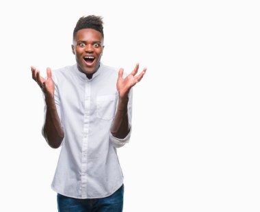 Afrikalı-Amerikalı genç deli kutluyor ve silah ile başarı için heyecanlı çığlık kaldırdı ve açık gözleri hayret izole arka plan üzerinde. Kazanan kavramı