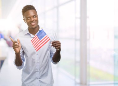 ABD bayrağı çok mutlu el ve parmak ile tarafına işaret tutan genç Afro-Amerikan adam