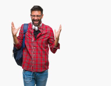 Üzerinde kulaklık ve sırt çantası giyiyor yetişkin İspanyol öğrenci adam arka plan deli kutluyor izole ve crazy arms ile başarı için kaldırdı ve heyecanlı çığlık gözler kapalı. Kazanan kavramı