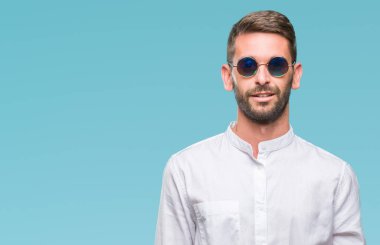 Yüzünde mutlu ve güzel bir gülümseme ile izole arka plan üzerinde gözlük takan yakışıklı delikanlı. Şanslı kişi.