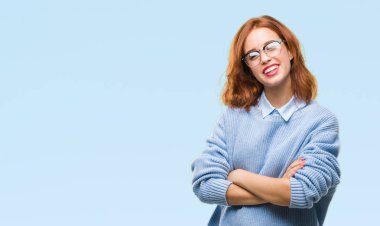 İzole arka plan kış kazak mutlu yüz çapraz silah kameraya bakarak ile gülümseyen giyen genç güzel kadın. Olumlu bir kişi.