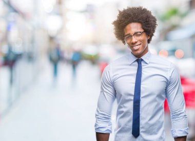 Gözlüklü seksi bir ifadeyle, neşeli ve mutlu yüzünü kameraya bakarak göz kırpıyor izole arka plan üzerinde Afro Amerikalı iş adamı.