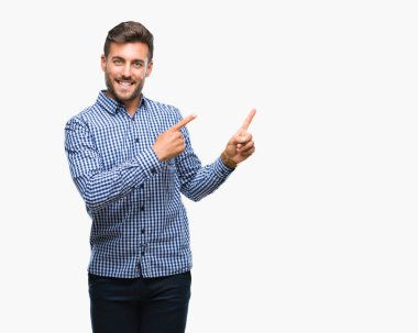 Yakışıklı delikanlı gülümseyen ve iki elleri ve parmakları ile tarafına işaret kamera bakarak izole arka plan üzerinde.