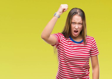 İzole arka plan öfkeli ve sinirli sinirli ve öfke ile bağırarak süre öfkeli yumruk yükselterek Genç beyaz güzel kadın. Öfke ve agresif kavramı.