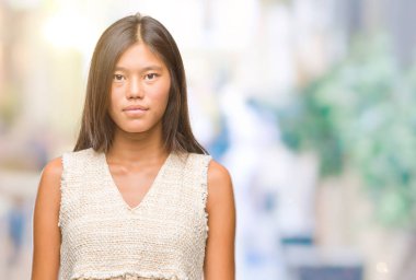 Genç Asyalı kadın yüzünde ciddi bir ifade ile izole arka plan üzerinde. Basit ve doğal kameraya bakıyor.