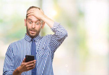 Genç atlatmışsınız adam manifatura izole arka plan baş, el ile vurguladı üzerinden Smartphone kullanarak ileti gönderme şok utanç ve sürpriz suratla, öfkeli ve sinirli. Korku ve hata için üzgün.