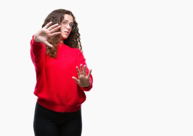 Güzel esmer kıvırcık saçlı Genç kız üzerinde gözlük ve kış kazak giyiyor şokta bağırarak arka plan korkuyor ve dehşet korku ifade dur hareketi el ile ile izole. Panik kavramı.