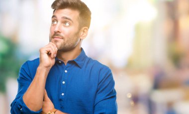 Yakışıklı delikanlı çene düşünme hakkında soru, dalgın ifade üzerine el ile izole arka plan üzerinde. Düşünceli yüzüyle gülümsüyor. Şüphe kavramı.