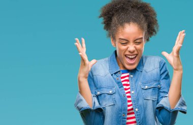 Genç afro Amerikalı kadın deli ve silah ile başarı için deli kutluyor izole arka plan üzerinde kaldırdı ve heyecanlı çığlık gözler kapalı. Kazanan kavramı