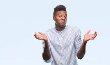 Afrikalı-Amerikalı genç izole arka plan clueless ve şaşkın bir ifadeyle kollar ve eller ortaya çıkar üzerinden. Şüphe kavramı.