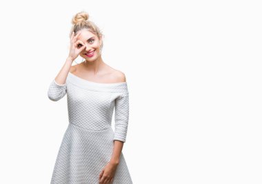 Genç güzel sarışın ve mavi gözlü kadın gülümsüyor, parmakları ile mutlu yüz üzerinden seyir göz el ile ok jest yapıyor izole arka plan.