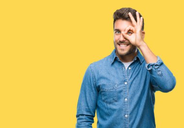 Genç yakışıklı adam gülümsüyor, parmakları ile mutlu yüz üzerinden seyir göz el ile ok jest yapıyor izole arka plan üzerinde.