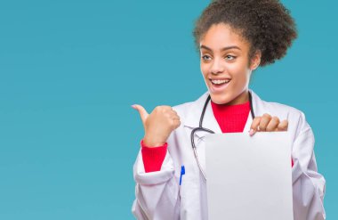 İşaret ve başparmak kadar mutlu yüz gülümseyen tarafı ile gösteren izole arka plan üzerinde boş kağıt tutan genç afro Amerikalı doktor kadın