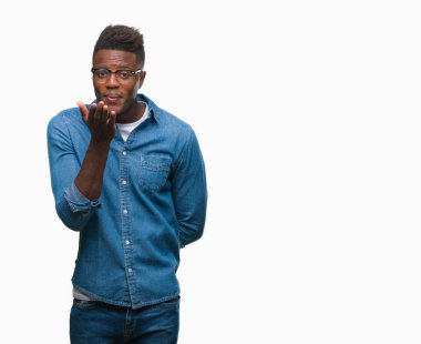 Afrikalı-Amerikalı genç bir öpücük el ile güzel ve seksi olmak hava üfleme kamera bakarak izole arka plan üzerinde. Aşk ifade.