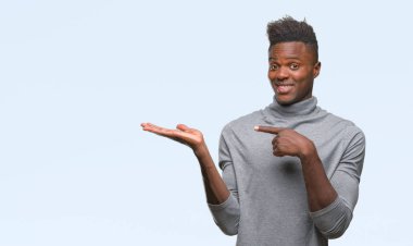 Genç Afro-Amerikan adam üzerinden hayran ve el ile sunulması ve parmak ile işaret ederken kameraya gülümseyen izole arka plan.