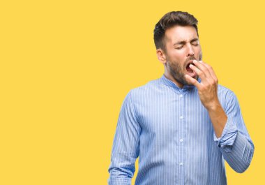 Yakışıklı delikanlı izole arka plan üzerinde el ile ağız kapsayan yorgun esneme sıkılmış. Restless ve uyku hali.