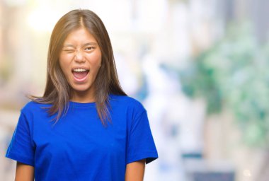 Genç Asyalı kadın seksi bir ifadeyle, neşeli ve mutlu yüzünü kameraya bakarak göz kırpıyor izole arka plan üzerinde.