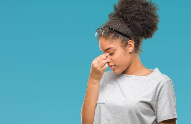 İzole arka plan yorgun sürtünme burun ve göz yorgunluğu ve baş ağrısı duygu üzerinde gözlük takan genç afro Amerikalı kadın. Stres ve hayal kırıklığı kavramı.