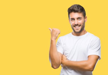 Yakışıklı delikanlı arıyor ve başparmak yanında yukarıyı mutlu yüz ile gülümseyen izole arka plan üzerinde.