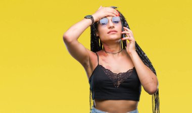 Genç örgülü saç Afro-Amerikan smartphone kafasına, utanç ve sürpriz yüz ile şok el ile vurguladı izole arka plan üzerinde konuşurken Doğum işareti ile öfkeli ve sinirli. Korku ve hata için üzgün.