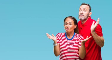 Orta yaş İspanyol kaç aşk izole içinde arka plan clueless ve şaşkın bir ifadeyle kollar ve eller kaldırdı. Şüphe kavramı.