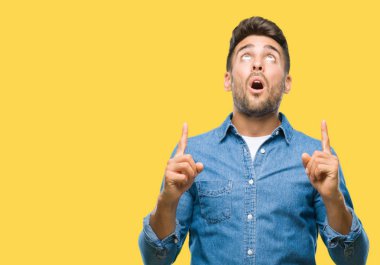 Yakışıklı delikanlı izole arka plan üzerinden hayran ve yukarıya bakıp parmakları ile işaret şaşırttı ve silah kaldırdı.