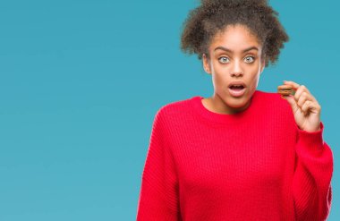Genç afro Amerikalı kadın çikolata macaron izole arka şok sürpriz yüzü, korkuyor ve korku ifadesi ile heyecanlı olan korkmuş üzerinden yemek