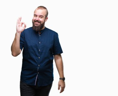 İzole arka plan el ve parmaklar ok işaretiyle yapıyor olumlu gülümseyen üzerinde genç beyaz hipster adam. Başarılı ifade.