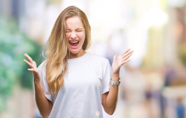 Arka plan deli kutluyor üzerinde rahat beyaz t-shirt giyen genç güzel sarışın kadın izole ve crazy arms ile başarı için kaldırdı ve heyecanlı çığlık gözler kapalı. Kazanan kavramı