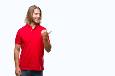 Seyir ve başparmak yanında yukarıyı mutlu yüz ile gülümseyen izole arka plan üzerinde uzun saçlı yakışıklı delikanlı.