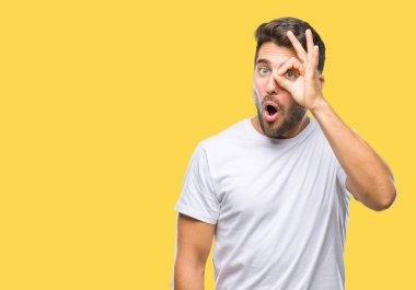 Sürpriz yüz, göz parmaklarının arasından seyir yakışıklı delikanlı ok jest yapıyor izole arka plan üzerinde şok. İmansız ifade.