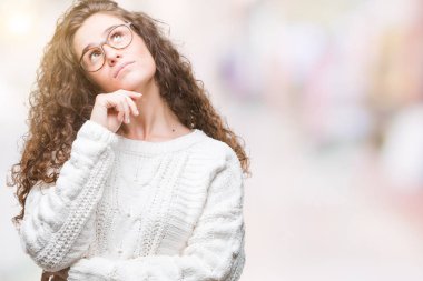 Arka plan ile ilgili soru, dalgın ifade düşünme çene yandan üzerinde kış kazak giyen genç kız izole güzel esmer kıvırcık saçlı. Düşünceli yüzüyle gülümsüyor. Şüphe kavramı.