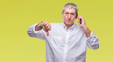 Kızgın yüz, eksi işareti aşağı antipati başparmak ile gösterilen, ret kavramı ile izole arka plan üzerinde Smartphone'da konuşan yakışıklı üst düzey adam