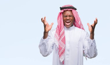 Kızgın ve çığlık kaldırdı ve kapalı gözleri heyecanlı silah ile başarı için deli kutluyor izole arka plan üzerinde geleneksel keffiyeh giyen genç Arapça Afrika adam. Kazanan kavramı