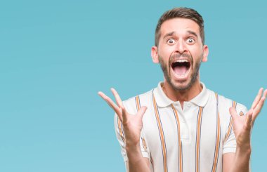 Yakışıklı delikanlı deli kutluyor ve silah ile başarı için heyecanlı çığlık kaldırdı ve açık gözleri hayret izole arka plan üzerinde. Kazanan kavramı