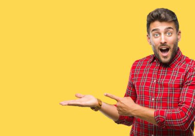 Yakışıklı delikanlı üzerinden hayran ve el ile sunulması ve parmak ile işaret ederken kameraya gülümseyen izole arka plan.