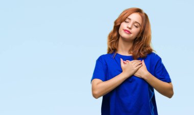 Genç güzel kadın ile gülümseyen izole arka plan yüzünden kapalı gözler ve yüzünde minnettar jest ile göğüs üzerinde eller. Sağlık kavramı.