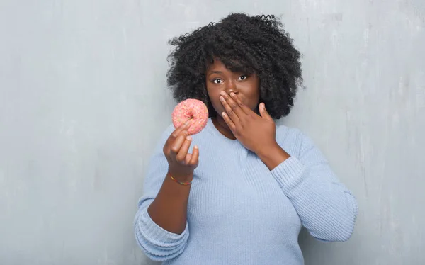 Unga Afroamerikanska Kvinnan Över Grå Grunge Vägg Ätande Rosa Donut — Stockfoto