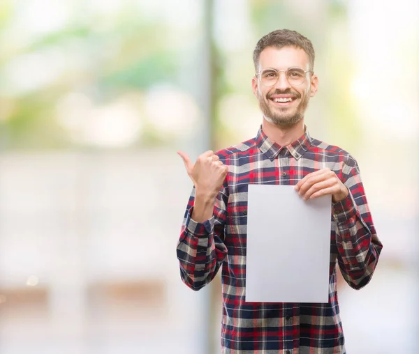 Joven Hipster Hombre Adulto Sosteniendo Hoja Papel Blanco Señalando Mostrando — Foto de Stock