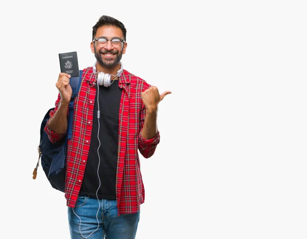 指していると幸せそうな顔を笑顔で側まで親指で示す分離の背景にアメリカのパスポートを保持している大人のヒスパニック学生男 — ストック写真
