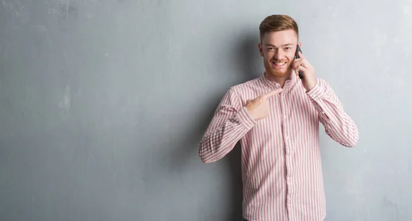 Joven Pelirrojo Hombre Sobre Gris Grunge Pared Hablando Por Teléfono — Foto de Stock