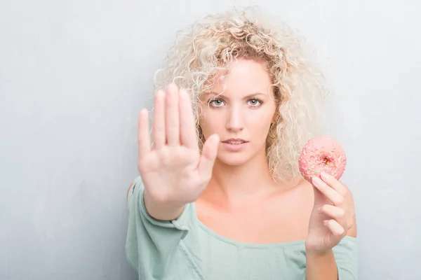 Joven Rubia Sobre Fondo Gris Grunge Comiendo Rosado Donut Con — Foto de Stock