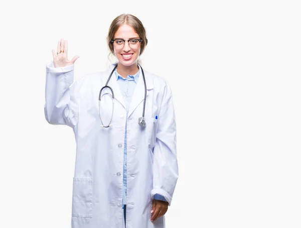 美丽的年轻金发碧眼的医生妇女穿着医疗制服在孤立的背景显示和手指指向第五 同时微笑着自信和快乐 — 图库照片